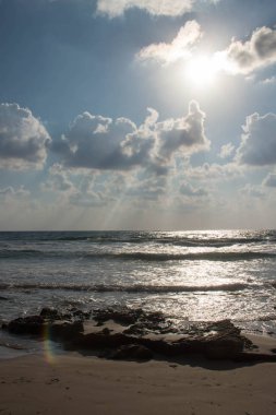 Dalgalar ve kabartma hava bulutlar güneş ışınları ile güzel deniz manzara
