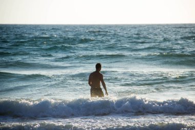 Genç çekici adam denizde banyoları