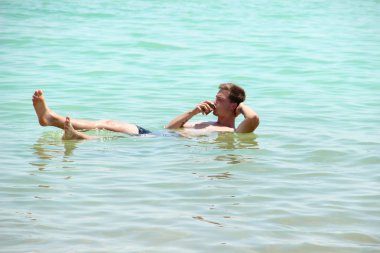 Ne kadar su yoğun gösterilen genç çekici biri el yardımı olmadan ölü deniz içinde yüzüyor