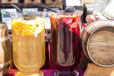 Kırmızı ve sarı içecekler ve ev yapımı şarap ile ahşap bir varil ile büyük cam kaplar