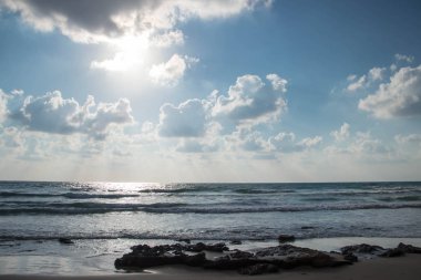 Dalgalar ve kabartma hava bulutlar güneş ışınları ile güzel deniz manzara