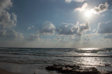 Dalgalar ve kabartma hava bulutlar güneş ışınları ile güzel deniz manzara