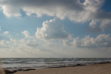Dalgalar ve kabartma hava bulutlar güneş ışınları ile güzel deniz manzara