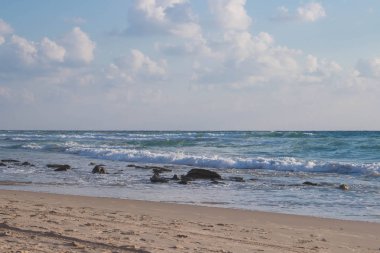 Dalgalar ve kabartma hava bulutlar güneş ışınları ile güzel deniz manzara