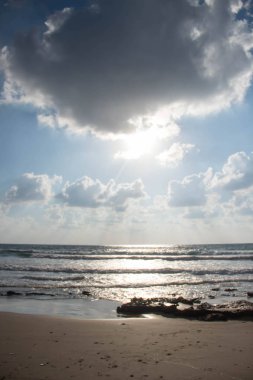 Dalgalar ve kabartma hava bulutlar güneş ışınları ile güzel deniz manzara