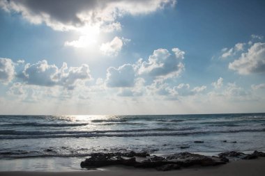 Dalgalar ve kabartma hava bulutlar güneş ışınları ile güzel deniz manzara