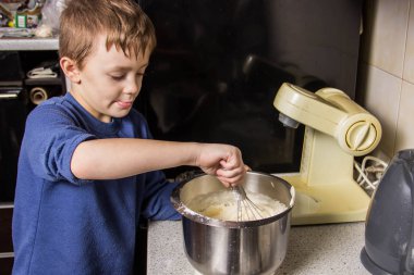 Maddeler ekleyerek Hamur karıştırıcı, cupcakes için çocuk mutfakta kneads
