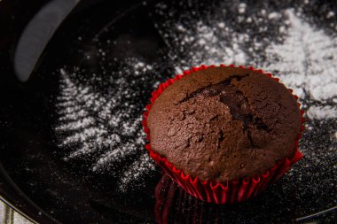 Bir dal dekorasyon ile karanlık bir arka plan üzerinde çikolatalı kek ile krema şeker boyalı