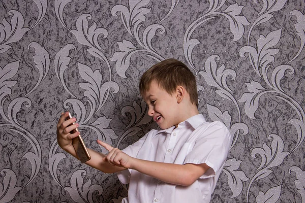 彼の手の中の携帯電話で白のシャツを着た少年 — ストック写真