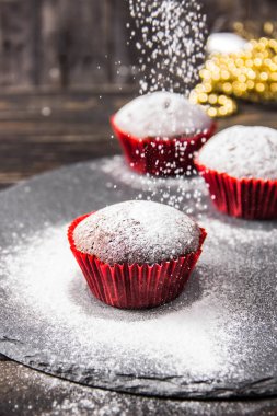 Krema şeker ile karanlık bir arka plan üzerinde üç çikolatalı kek