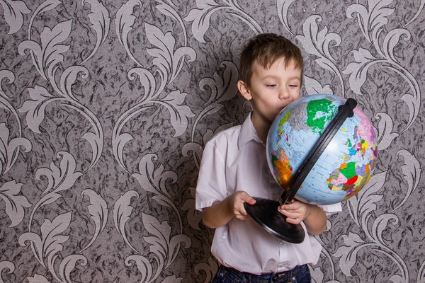 Ein Junge Mit Einer Weltkugel Und Einem Flugzeug Der Hand — Stockfoto
