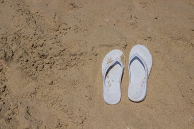 Altın kum üzerinde beyaz terlik