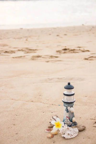 Bela decoração na forma de um farol e conchas na areia com espaço para o texto — Fotografia de Stock