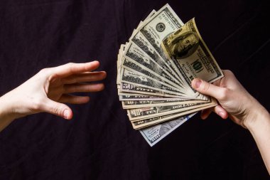 Siyah bir arka plan üzerinde a yelpaze-in dolar tutan eller