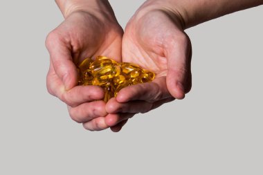 Açık renkli ellerinde sarı hap kapsül