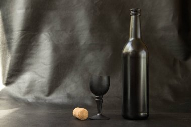 Siyah deri arka plan üzerinde siyah camlı siyah şarap şişesi