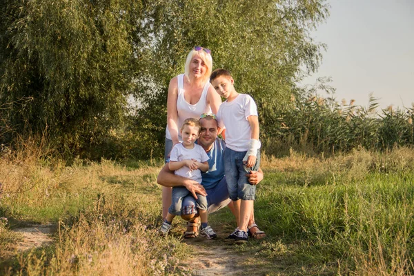 休憩と白い シャツとデニムのショート パンツでは自然の再生の大きな幸せな家族 — ストック写真