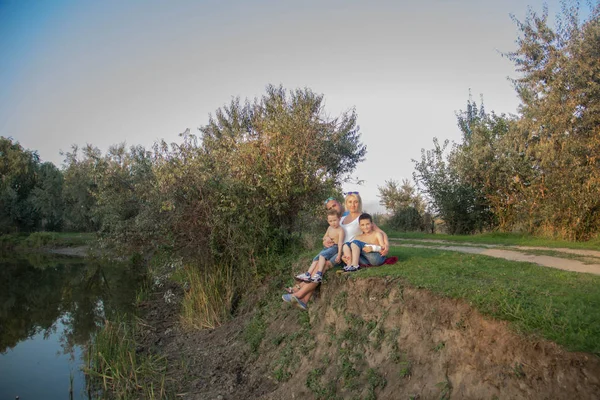 Happy Beautiful Family Two Sons Sitting Nature Lake Sunset — Stock Photo, Image