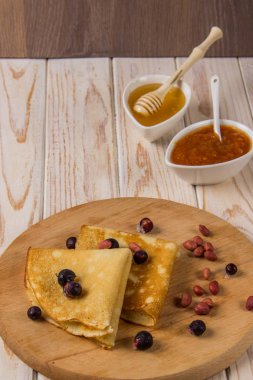 Bal, reçel ve çilek ile ahşap bir gemide krep