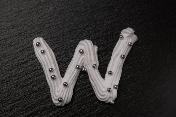 Stock image Whipped cream letters decorated with silver beads