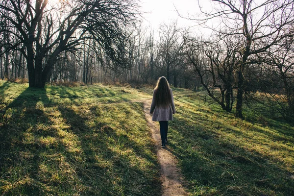 Menina bonita com longos cabelos loiros de volta contra o fundo da floresta — Fotografia de Stock