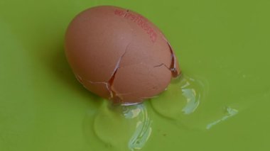 Yeşil arka planda kırılmış tavuk yumurtası, yakın görüş. 