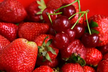 Beyaz arka planda izole edilmiş çilek ve kirazlara yakın çekim, yaz meyveleri konsepti, yakın görüş  
