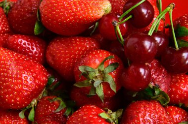 Beyaz arka planda izole edilmiş çilek ve kirazlara yakın çekim, yaz meyveleri konsepti, yakın görüş  