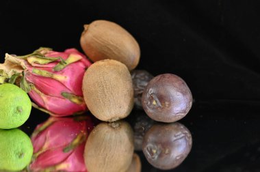 Siyah zemin üzerinde olgun egzotik meyveler seti, sağlıklı gıda konsepti. 