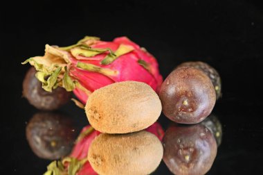 Siyah zemin üzerinde olgun egzotik meyveler seti, sağlıklı gıda konsepti. 