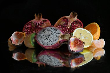 Siyah zemin üzerinde olgun egzotik meyveler seti, sağlıklı gıda konsepti. 