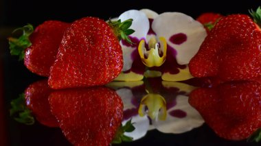 Koyu arkaplanlı çilekli güzel orkide çiçekleri, yaz konsepti, yakın görüş  
