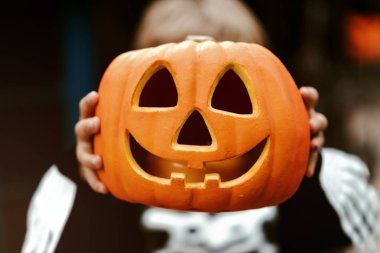 Cadılar bayramı balkabağı tutan çocuk