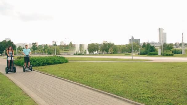 Amare coppia cavalca un hoverboard sulla strada in città — Video Stock