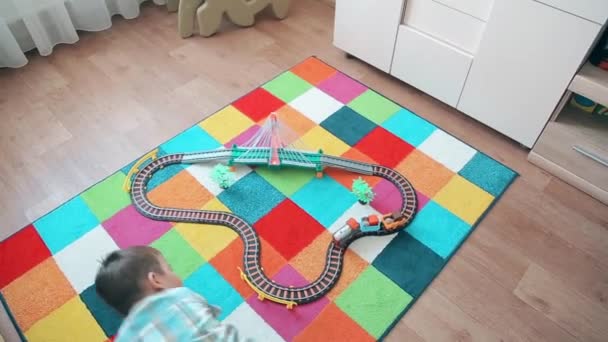 Un niño pequeño juega en el tren, corriendo detrás de él para adelantar — Vídeos de Stock