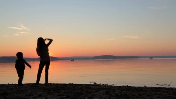 Children at sunset throw pebbles into the sea HD 1920x1080 — Stock Video