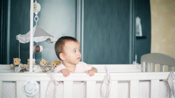 Маленькая девочка плачет стоя в детской кроватке HD 1080p — стоковое видео