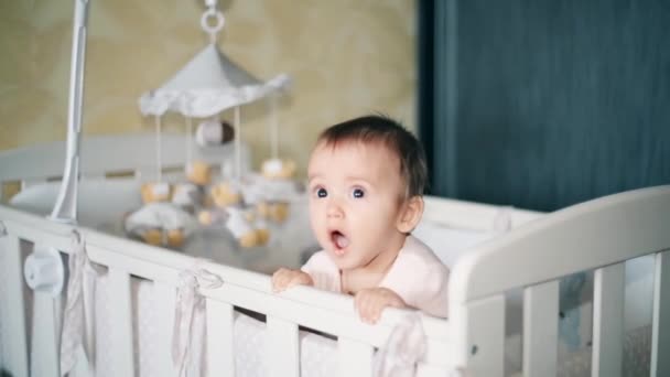 一个小女孩站在婴儿床里仔细地看着一个人1080p 高清 — 图库视频影像