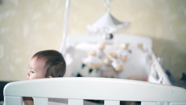 Маленькая девочка плачет стоя в детской кроватке 1920 HD — стоковое видео