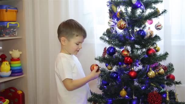 Um menino olha para a árvore de Natal brinquedos HD 1920x1080p — Vídeo de Stock