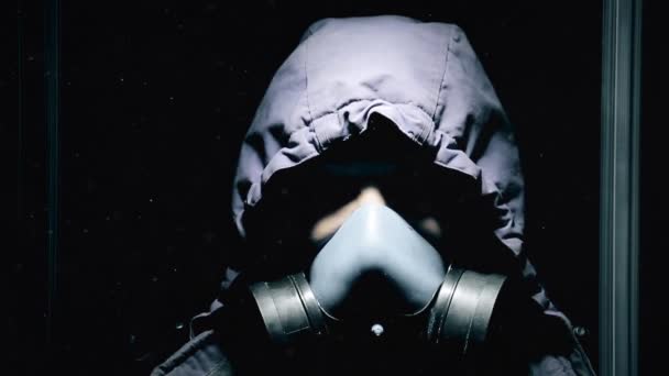 En kille i mörka slutna rum är stående i en gasmask och andas tungt Hd — Stockvideo