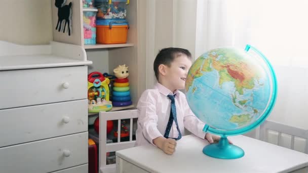 Un petit enfant cherche un endroit sur le globe où il a grandi. — Video