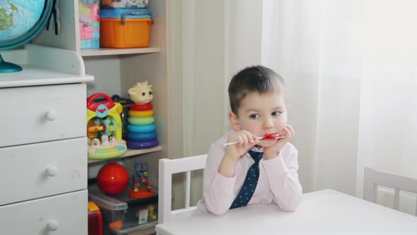 Un bambino mangia caramelle rosso HD 1920 — Video Stock