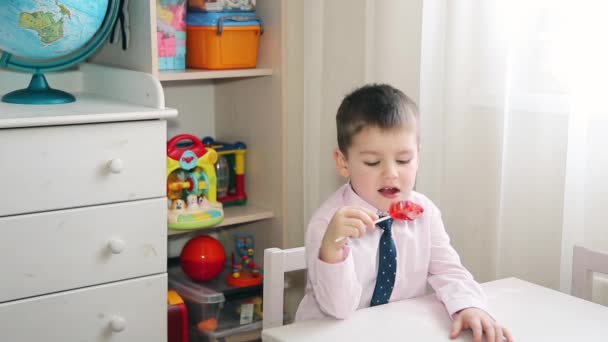 Een klein kind eet snoep rode 19209x1080p Hd — Stockvideo