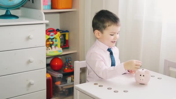 Den lilla pojken räknar pengar i spargrisen — Stockvideo