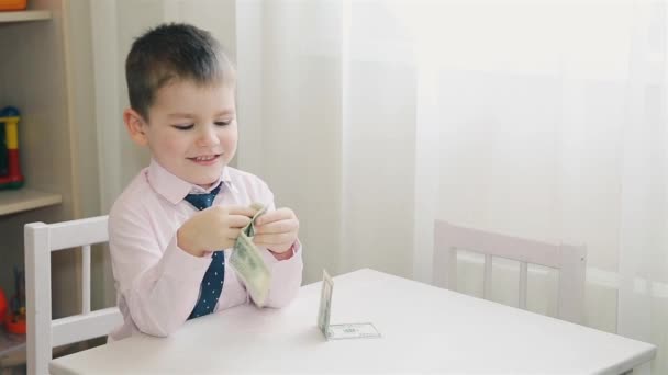 Маленький мальчик складывает бумажные деньги HD 1080p — стоковое видео