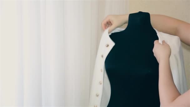 Девушка дизайнер женская одежда надеть куртку манекена в белом — стоковое видео
