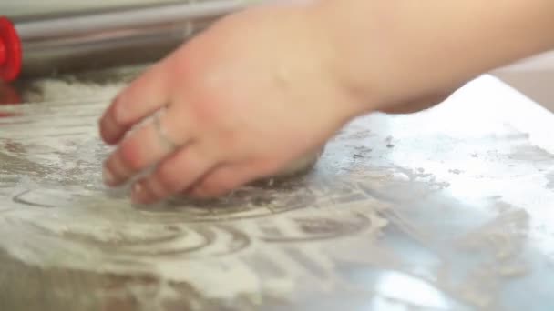 Womens hands roll out the dough with a rolling pin on the kitchen table — Stock Video