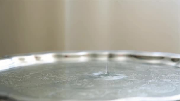 Goccia d'acqua rallentata che cade su vassoio metallico con motivo HD — Video Stock
