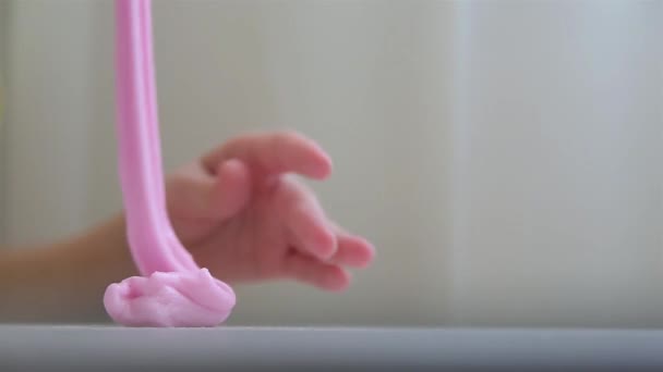 Baby zittend op witte tafel en spelen roze slijm HD 1920x1080 — Stockvideo